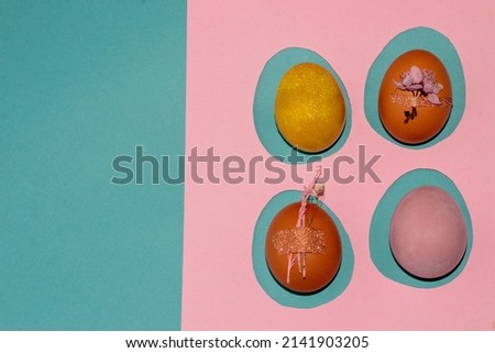 four colorful eggs on a pink template and a naughty background, creative art easter design, copy space and holiday greeting card
