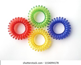 Four colorful spiral rubber bands. Elastic hair ties in vibrant colors on white background. 