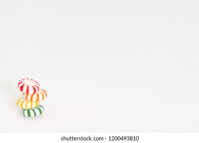 Four Colorful Starlight Mints Stacked On A White Background