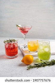 Four Colorful Summer Cocktails In Glasses On  White Table. Assortment Of Fresh  Summer Drinks. Pink And Red Sangria Cocktails, Orange Punch Cocktail, Margarita Cocktail, Tropical Mule.