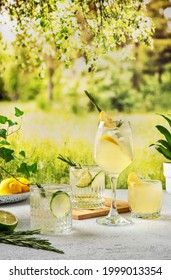 Four Colorful Summer Cocktails On The Table. Hard Seltzer Cocktails With Various Fruits: Lime And Lemon. Summer Party Table Outdoor In A House Backyard With сold Summer Drinks.  