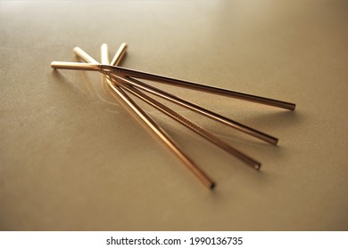 Four Copper Drinking Straws Arranged On A Kitchen Counter