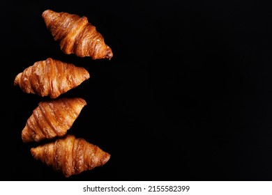 Four croissants lie on a black background. View from above. - Powered by Shutterstock