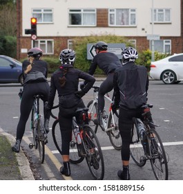 Four Cyclists In Their Winter Cycling Lycra Gear Waiting At A Traffic Light