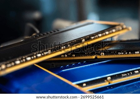 Four DDR memory chips in different colors lying on a blue printed circuit board.