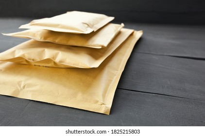 Four different size of paper envelopes on the wooden table