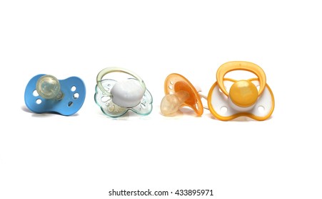 four dirty pacifiers on a white background - Shutterstock ID 433895971