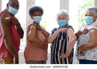 Vier verschiedene männliche und weibliche Senioren tragen Gesichtsmasken, die nach der Impfung Putztiere zeigen. Seniorengesundheit und Lebensstil während der Covid 19 Pandemie.
