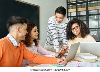 Four Diverse Multiracial Young Happy Cheerful Coworkers Business Startup Gen Z Creative Team Students Brainstorming Discussing Online Project With Asian Mentor Leader In Classroom Office Using Laptop.