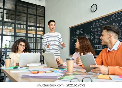 Four diverse multiracial young professional business startup gen z team students group working on project listen to Asian leader in contemporary office classroom with gadgets. Diversity concept. - Shutterstock ID 2021619692