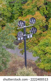 Four Electric Reflectors Lamps At Light Pole In City Park Day