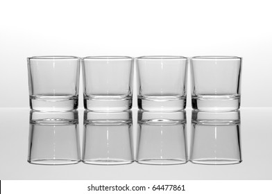 Four Empty Shot Glasses On White Background.