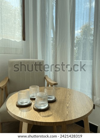 Four Empty Whiskey of coffee Glasses on Wooden Table with Saucers, Sheer White Curtain Backdrop, and White Chairs in a Café coffee shop