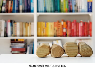 Four Empty Wooden Blocks In Front Of Home Library. Blank Wood Blocks Mockup And Blurred Bookshelf.