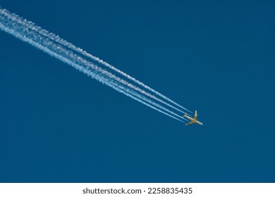 four engine jet aricraft with contrail on a blue sky