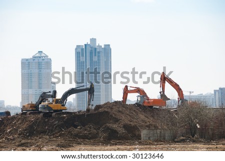 Four excavators work on a constuction site