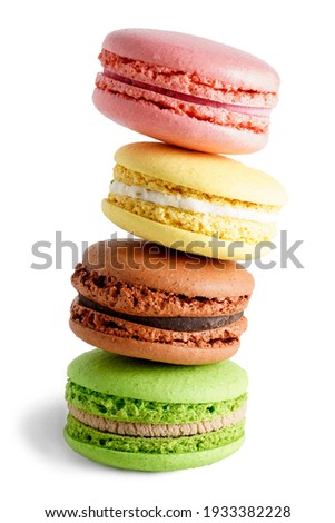 Four falling colorful green, yellow, pink and brown macaroons isolated on white background. Sweet And Colourful French cookies Macaroons.                             