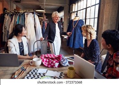 Four Fashion Designers In Meeting Discussing Garment - Powered by Shutterstock