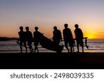 Four fishermen carrying their boat at Roa Beach, Sumba Island, Indonesia