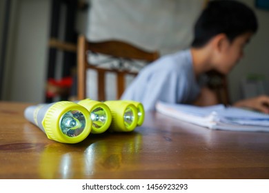 Four Flashlights On A Table For A School Science Experiment. A Sixth Grader In The Back In Bokeh As He Leans In For Research. 