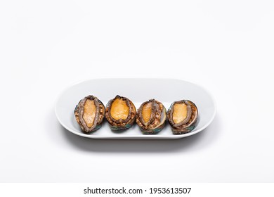 Four fresh abalone in a white dish