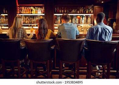 Four friends at the counter in bar, back view - Powered by Shutterstock