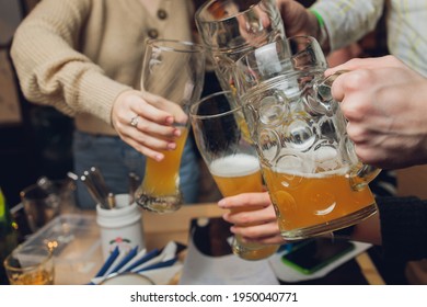 Four friends with a fresh beer in a Beer garden close-up on beer stein. - Shutterstock ID 1950040771