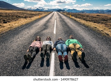 four friends lie down on the asphalt road - Powered by Shutterstock