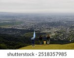 Four friends observe the city of San Miguel de Tucuman (Argentina) from a lookout point