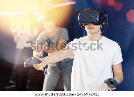 Four friends using virtual reality headset and controlling joysticks