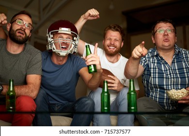 Four Friends Are Watching American Football Game, Cheering In Front Of Television