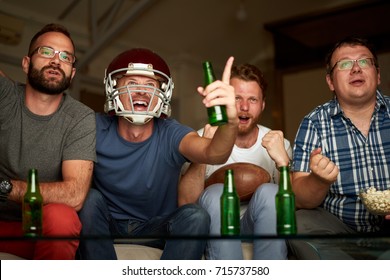 Four Friends Are Watching American Football Game, Cheering In Front Of Television