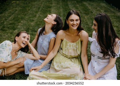 Four Friends, Young Women, Sitting In A Park On Green Grass, Having Good Time.