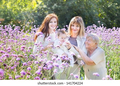 Four Generations Of Beautiful Women In A Blooming Garden