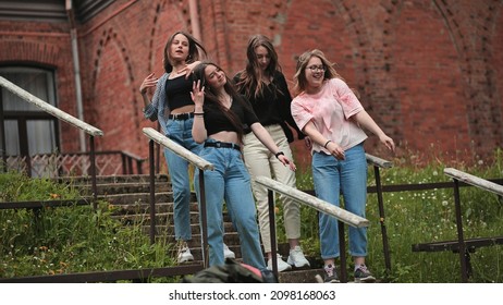 Four girls are actively singing dancing and relaxing in the park