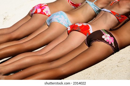 Four girls in bikini lying on the sand