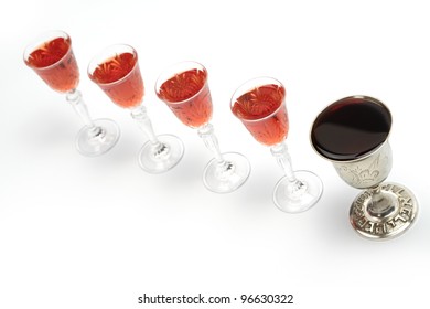 Four Glasses Of Wine And One Silver Cup For Passover Seder.Isolated