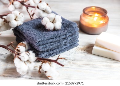 Four gray terry face towels, two bars of soap, a candle in a glass jar, and a branch of cotton at the spa. Beauty saloon. Comfort and care - Shutterstock ID 2158972971