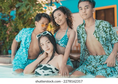 Four happy asian friends posing in colorful swimwear at the swimming pool at a resort. Two couples on a double date having a fun time. - Shutterstock ID 2278162317