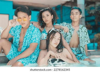 Four happy asian friends posing in colorful swimwear at the swimming pool at a resort. Two couples on a double date having a fun time. - Shutterstock ID 2278162345