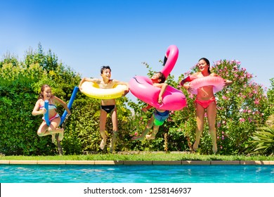 Four Happy Friends Jumping Into The Swimming Pool