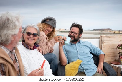 Four Happy People Together, Senior And Middle-aged People Having Fun Eating And Drinking Outdoors On The Terrace - Couples Different Generations And The Same Love Concept