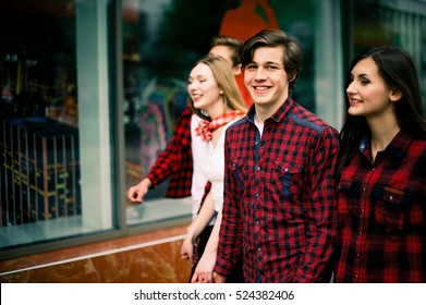 Four Happy Trendy Teenage Friends Walking In The City, Talking Each Other And Smiling. Lifestyle, Friendship And Urban Life Concepts.