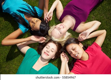 Four happy young women holding their hands