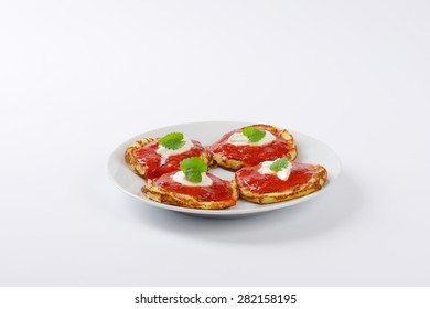 four hot pancakes with strawberry jam on white plate - Powered by Shutterstock