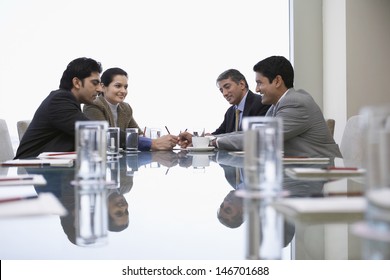 Four Indian Business People Discussing At Conference Table