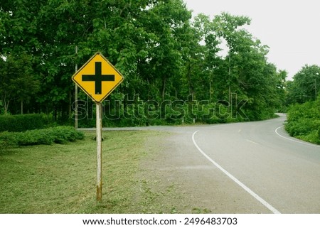 Four intersection yellow traffic sign, A road sign warns of an intersection ahead. 
