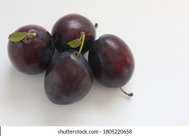 Four Italian Prune Plums On A Table Top