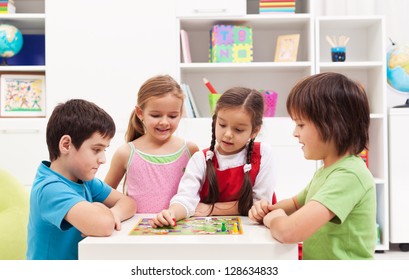 Four Kids Playing Board Game In Their Room