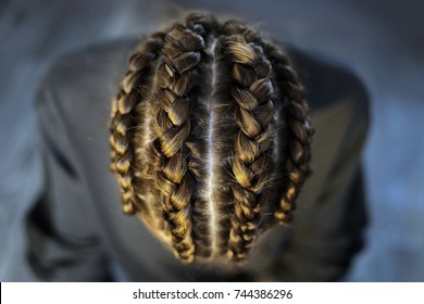 four large thick braids braided on the girl's head close-up on a